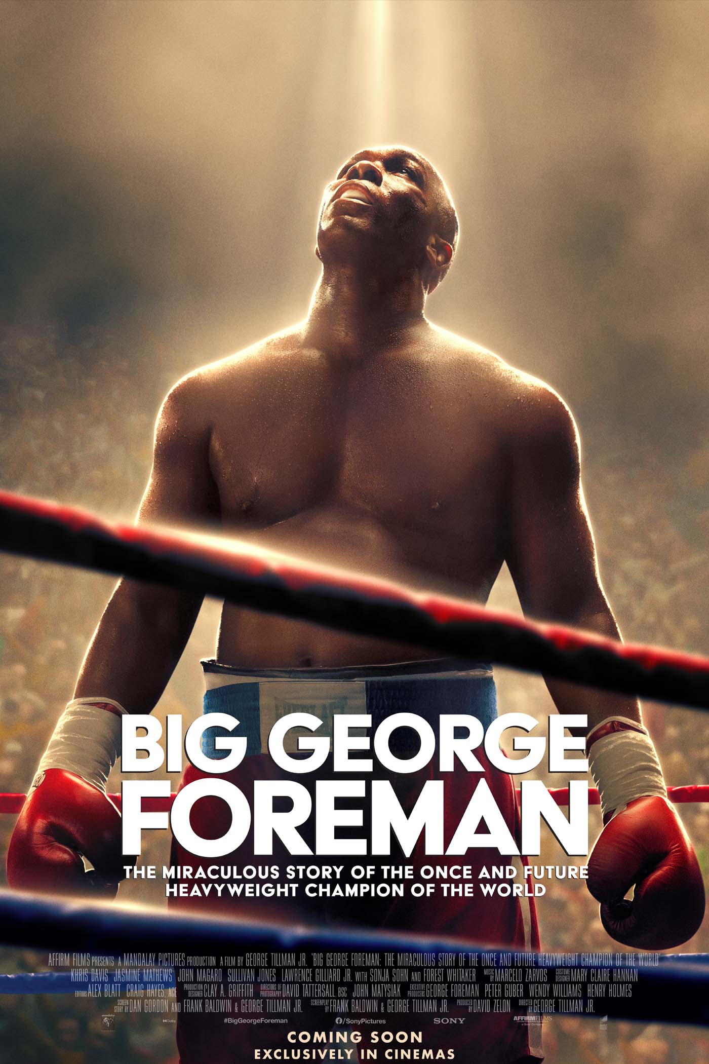 George Foreman standing in a ring looking up at the light